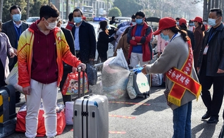 Voluntária aplica desinfetante sobre a bagagem de um aluno em Bozhou, na província de Anhui, no leste da China. (Foto: AFP)