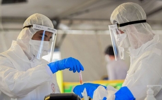 Médicos manuseiam uma amostra de teste de coronavírus em Tel Aviv. (Foto: Flash90) 