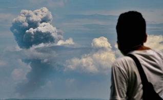 Homem observa fumaça do vulcão Krakatoa em erupção na Indonésia. (Foto: Ronald Siagian/AFP)