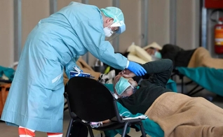 Equipe médica ajuda pacientes dentro do hospital Spedali Civili em Brescia, na Itália. (Foto: Flavio Lo Salzo/Reuters)