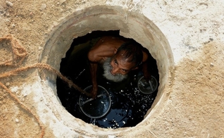 Jamshed Eric trabalhando em um esgoto em Karachi no ano passado. (Foto: Reprodução/NYT)