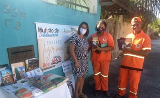 A mesa solidária despertou a atenção de dois profissionais de limpeza urbana que quiseram pegar livros religiosos. (Foto: Arquivo pessoal)