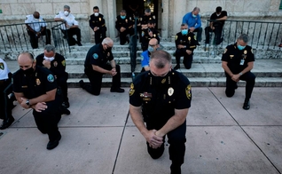 Policiais se ajoelharam durante um comício em Coral Gables, Flórida, no sábado, em resposta à morte de George Flay. (Foto: Eva Marie Uzcategui / AFP via Getty Images)