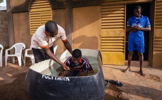 Pastor de Burkinabé, Bonogo Fulgence, batiza dois caminhoneiros em Ouagadougou, Burkina. (Foto: Reprodução / IMB)