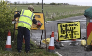 Trabalhador remove suástica pintada em uma placa na entrada de uma estrada fechada e parque de estacionamento perto do farol de Whitley Bay, em Northumberland, Inglaterra, quinta-feira, 30 de abril de 2020. (Foto: Owen Humphreys / AP)