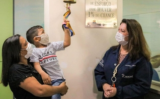 Brener Lorenzo, de 4 anos, toca o sino da cura após dois anos e meio de tratamento. (Foto: Governo do Amazonas)