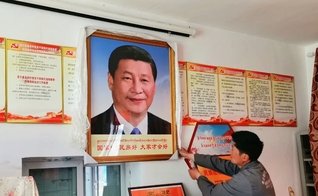 Homem pendura um retrato do presidente chinês Xi Jinping, no condado de Dzoge, no leste do Tibete. (Foto: Free Tibet)