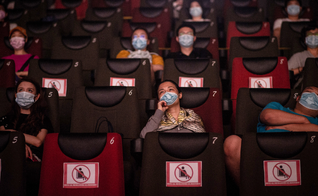 As pessoas assistem a um filme no dia 20 de julho, no primeiro dia da reabertura dos cinemas chineses em Wuhan, na província de Hubei. (Foto: Reprodução / AFP)