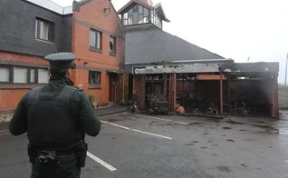 Policial observa igreja incendiada na Irlanda do Norte. (Foto: Reprodução / Bíblia Todo)