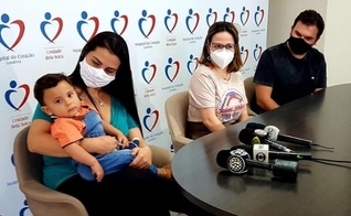 Heitor Araújo nos braços de sua mãe e junto ao pai em entrevista coletiva no dia da alta médica. (Foto: Reprodução / Hospital do Coração)