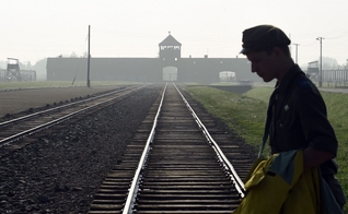 Homem atravessa trilhos do antigo campo de concentração de Auschwitz, na Polônia. (Foto: AP/Alik Keplicz)