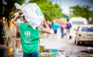 Voluntário carrega doações durante uma das ações realizadas pela agência humanitária (Foto: ADRA Brasil)