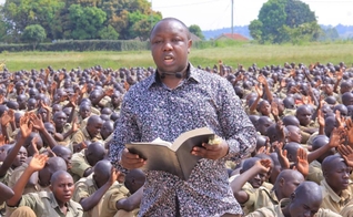 O pastor Samuel Kasigwa compartilha o Evangelho na véspera de Ano Novo com milhares de recrutas da Polícia em treinamento em Kabalye. (Foto: Reprodução / UGCN)