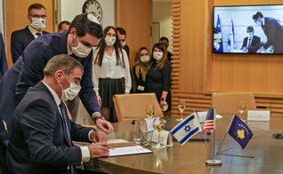 O ministro israelense das Relações Exteriores Gabi Ashkenazi assina documento de normalização das relações diplomáticas com Kosovo. (Foto: Reprodução / AFP)
