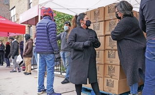 A voluntária Gloria Martinez, à esquerda, fala com Sofia Moncayo, que dirige um programa de distribuição de alimentos por meio da Mosaic West Queens Church. (Foto: Emily Leshner / AP)