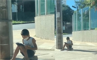 Nícolas lendo a Bíblia na calçada. (Foto: Reprodução / Instagram)