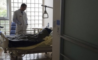 O Dr. Stephane Mercier visita um paciente na unidade de cuidados paliativos do hospital AP-HP Paul-Brousse em Villejuif, perto de Paris. (Foto: Reuters)