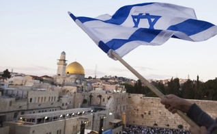 Bandeira israelense sendo hasteada perto do Muro das Lamentações no Dia de Jerusalém, em 13 de maio. (Foto: Lior Mizrahi/Getty Images)