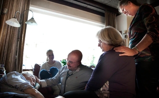 A família e o médico Sjef Boesten (com estetoscópio) se reúnem enquanto a vida de Siep Pietersma se esvai (Foto: Mona van den Berg)