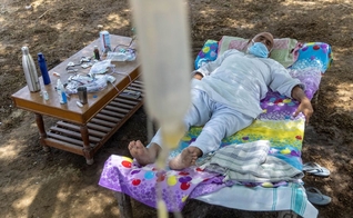 Um paciente Covid-19 recebe tratamento em uma clínica improvisada ao ar livre na vila de Mewla, Uttar Pradesh. (Foto: Reprodução / Reuters)