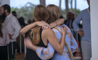 Depois de ouvir a notícia do colapso do prédio do condomínio, os moradores se agarram uns aos outros em Miami, EUA. (Foto: Billy Graham Association). 