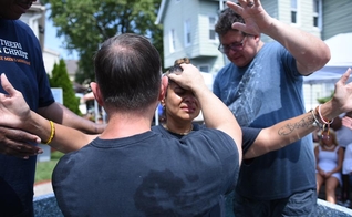Pastor Steve Hannett ora por mulher durante batismo. (Foto: Abundant Grace Christian Church)