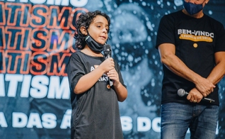 Arthur Ansuattigui, de 10 anos, conta testemunho ao lado do pastor Josué Valandro Jr. (Foto: Igreja Batista Atitude)