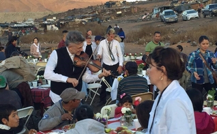 O evangelista Georgian toca violino durante ação social em comunidade pobre. (Foto: Reprodução/Facebook).