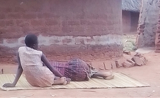 Harriet Nanzala descansa ao lado de sua filha no leste de Uganda. (Foto: Reprodução / Morning Star News)