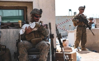 Soldado norte-americano cuida de bebê afegão: imagens sensibilizaram o mundo. Foto: (Departamento de Defesa dos Estados Unidos).