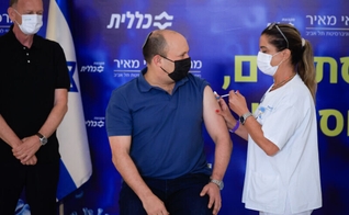 O primeiro-ministro israelense Naftali Bennett recebe a terceira dose da vacina Covid-19, em Kfar Saba. (Foto: Olivier Fitoussi/Flash90).