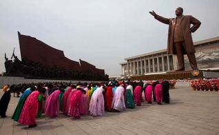Norte-coreanos prestam reverência a uma estátua de Kim Il-Sung, que criou sua própria religião em Pyongyang. (Foto: David Gittenfelder/AP/Veja)