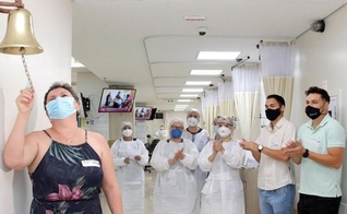Geane ao tocar o “sino da vitória” por finalizar o processo de quimioterapia. (Foto: Divulgação/Hospital de Base)