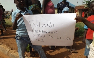 Nigerianos seguram uma placa pedindo o fim dos assassinatos. (Foto: Reprodução / ECCVN)