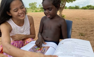 Rachel lendo o livro de sua autoria “Adotados em Amor” para uma criança Yolngu. (Foto: Reprodução/Eternity)