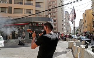 Um homem dispara sua arma no bairro de Tayuné durante os confrontos desta quinta-feira no Líbano. (Foto: Anwar Amro / AFP)