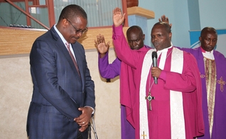 Joseph Ntombura, bispo da Igreja Metodista no Quênia, ora pelo ex-governador de Nairóbi Evans Kidero em 2015. (Foto: Fredrick Nzwili/RNS)