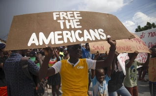 Grupo de haitianos protestaram pela libertação dos missionários sequestrados. (Foto: AP Photo/Joseph Odelyn).