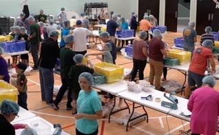 Voluntários com a Igreja Unity de Greenville embalando refeições para os necessitados na Zâmbia. (Foto: Reprodução / Cortesia da Igreja Unity)