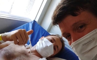 Arlen Isaak dá um sinal de positivo ao receber visita de um amigo no hospital. (Foto: Cynthia Isaak/Facebook)