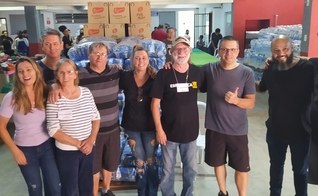 O presidente do Conselho dos Ministros Evangélico do Município de Petrópolis (Comempe), Pr. Carlos Carnavalli (ao centro de camiseta preta) e equipe em polo de doações. (Foto: Pr. Carlos Carnavalli)