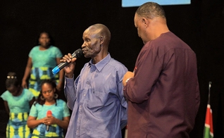 Homem conta seu testemunho após receber oração do Pr. Gerald Mwebe, no culto de Páscoa. (Reprodução / UGCN)