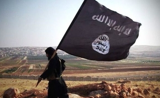 Militante islâmico com a bandeira do grupo terrorista. (Foto: Wikipedia)