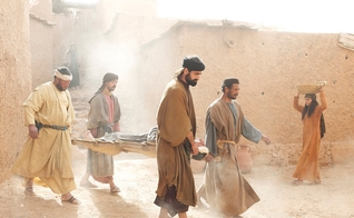 Amigos levam paralítico até Jesus para ser curado. (Foto: FreeBible)