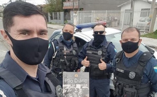 Imagem representativa de policiais segurando exemplares. (Foto: Pão Diário/Facebook)