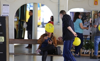 Estudante entrega balão e conversa com passageira no terminal de ônibus. Alunas posam para foto durante mobilização em semáforos. (Foto: Paulo Ribeiro)