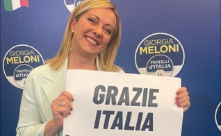 Giorgia Meloni durante discurso à imprensa, segurando placa ‘Obrigada Itália’. (Foto: Reprodução/Facebook/ Giorgia Meloni)