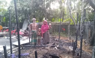 Família diante da casa incendiada. (Foto: Open Doors)
