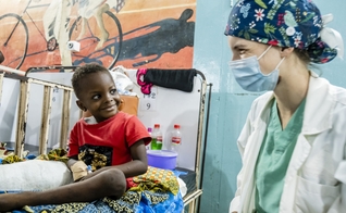 A voluntária médica Anna Leigh Breedlove brinca com uma criança na ala pediátrica do Baptist Medical Center de Nalerigu, Gana. (Foto: IMB).