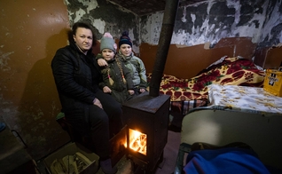 Olena e seus filhos em seu porão com o fogão doado pela Samaritan’s Purse. (Foto: Samaritan’s Purse).
